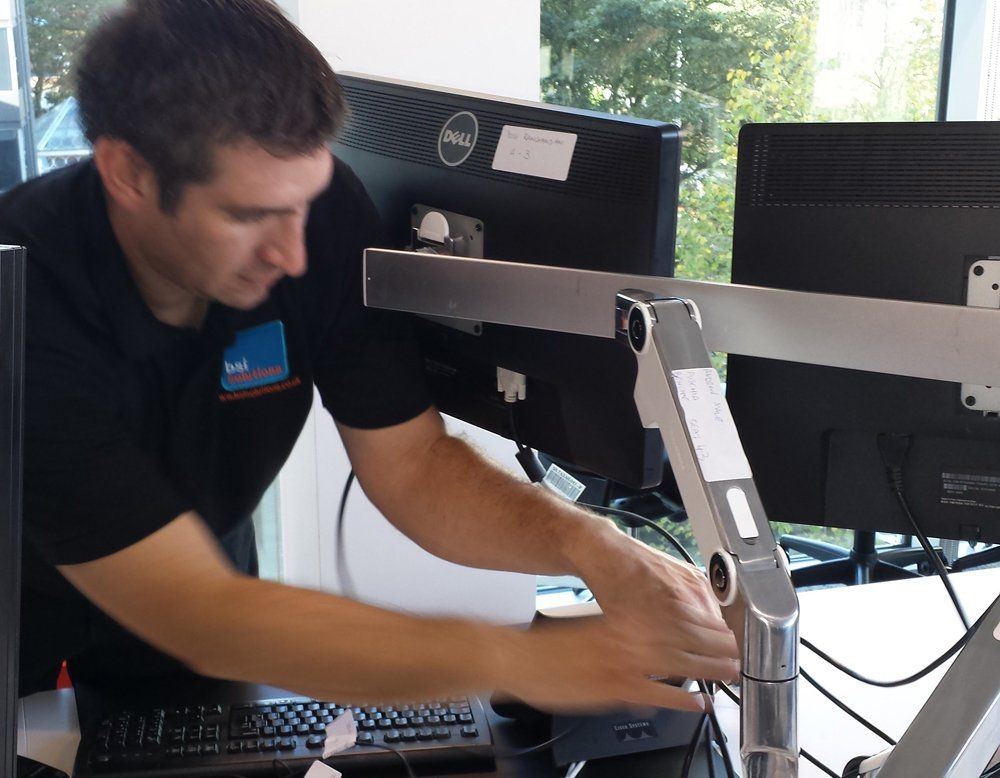 A man is working on a dell computer monitor