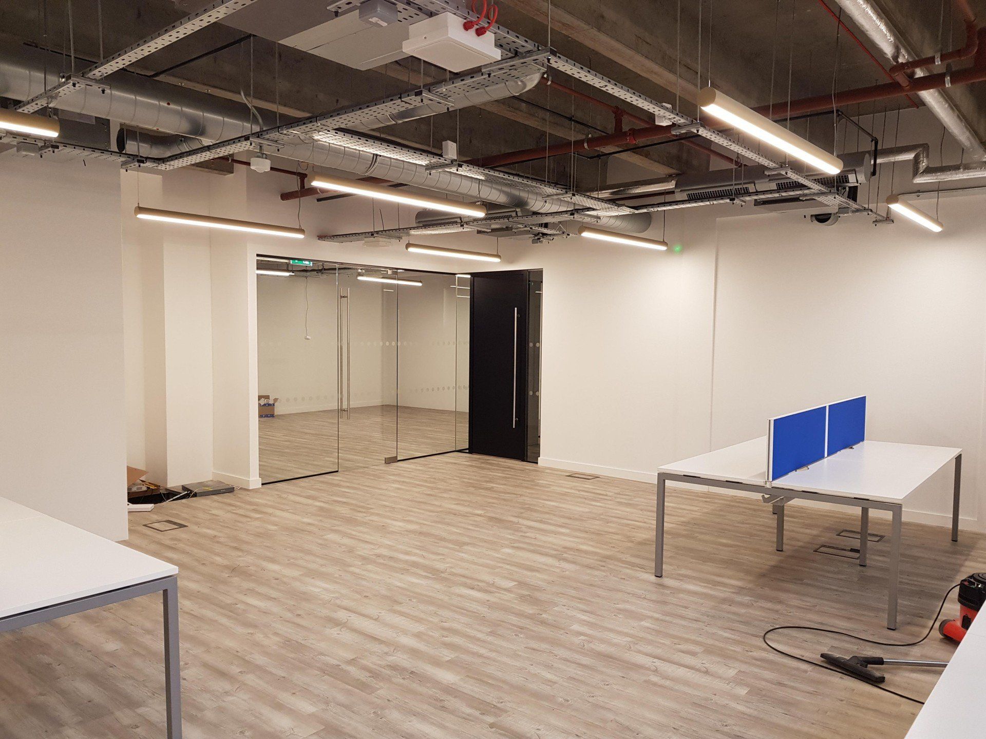 A large empty room with tables and a mirror on the wall.