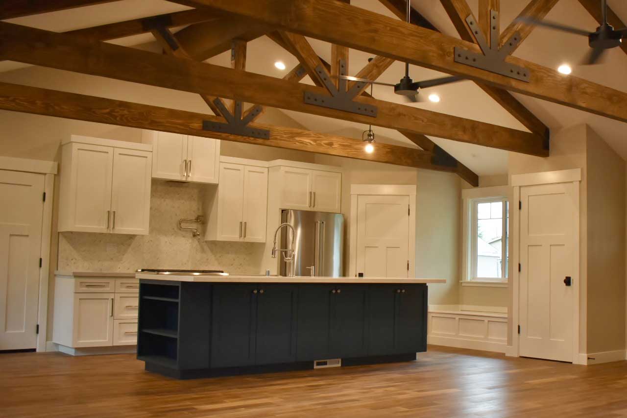 Open kitchen remodeling project with exposed wood beams, custom tile work, and a quartz counter top