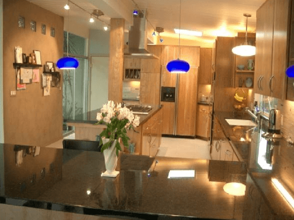 Interior kitchen design with custom cabinets and wood panel refrigerator accent