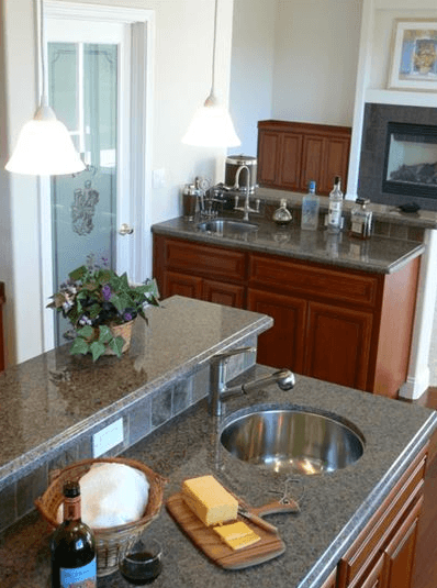 Kitchen bar area with marble counter tops and custom stone backsplash