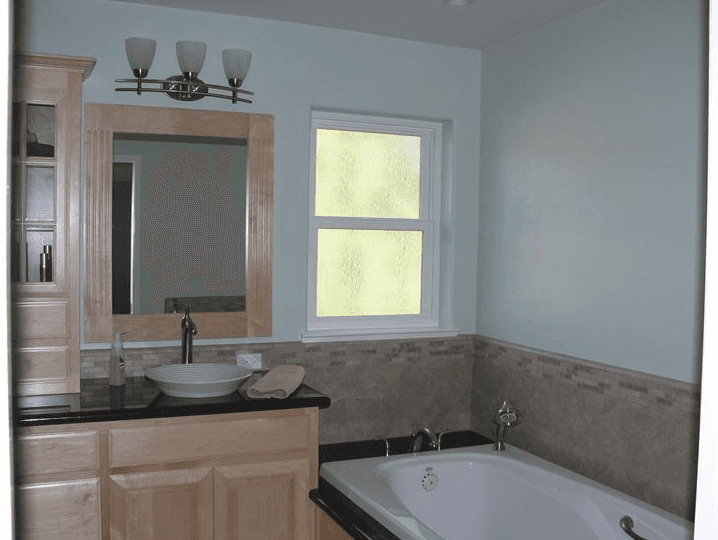 Light colored wood custom cabinets for a bathroom vanity with dark quartz counter tops