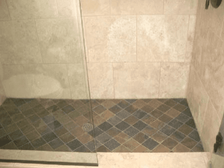 Interior of a shower enclosure with custom tile and stone floors