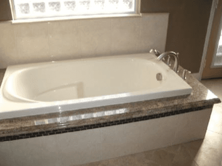Square corner bathtub with custom stone and quartz details