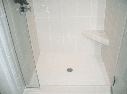 Shower enclosure with white custom tile work and floors