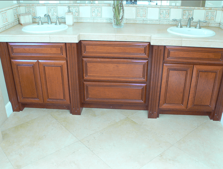 Dark brown custom cabinets with dual sinks and vanities