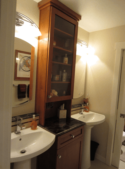 Custom cabinets inbetween dual bathroom vanities and pedestal sinks