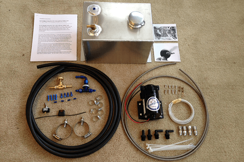 A stainless steel tank is surrounded by various pieces of equipment