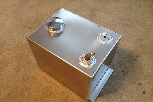 A stainless steel box is sitting on a carpeted floor