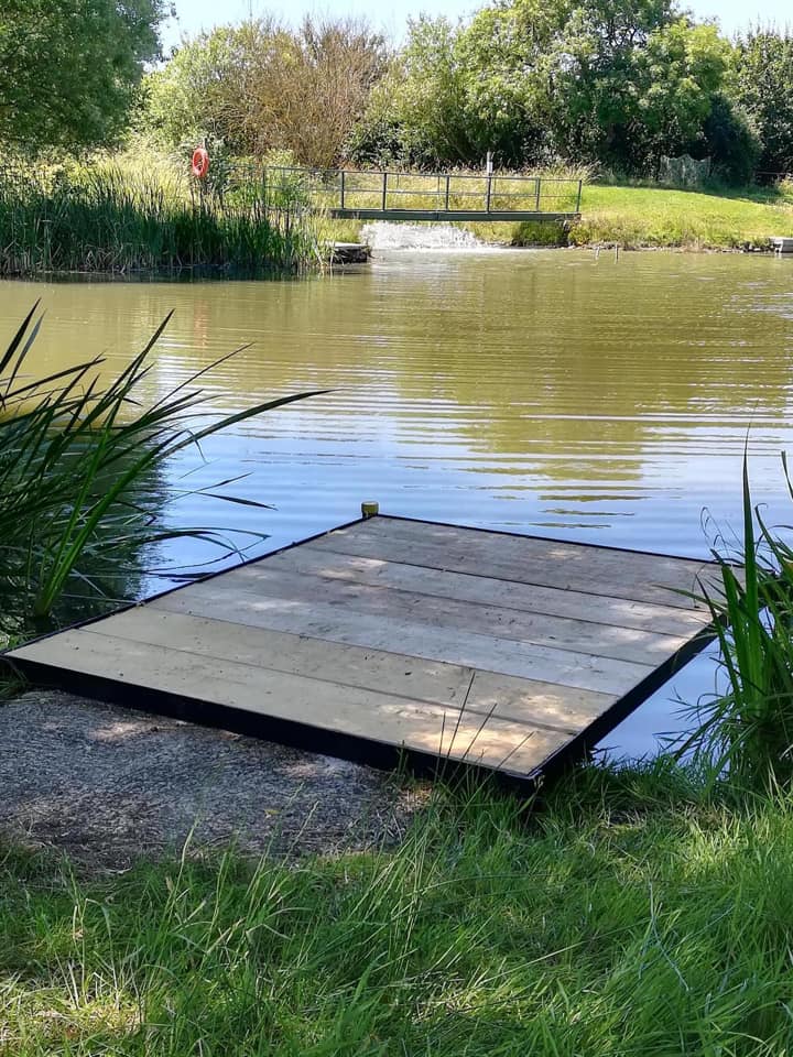 A wooden dock is sitting next to a lake.
