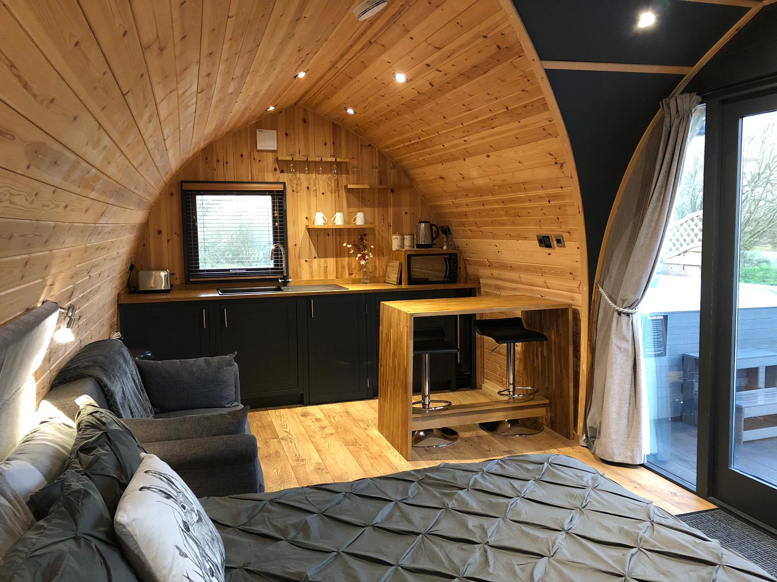A living room with a bed , couch , and kitchen.