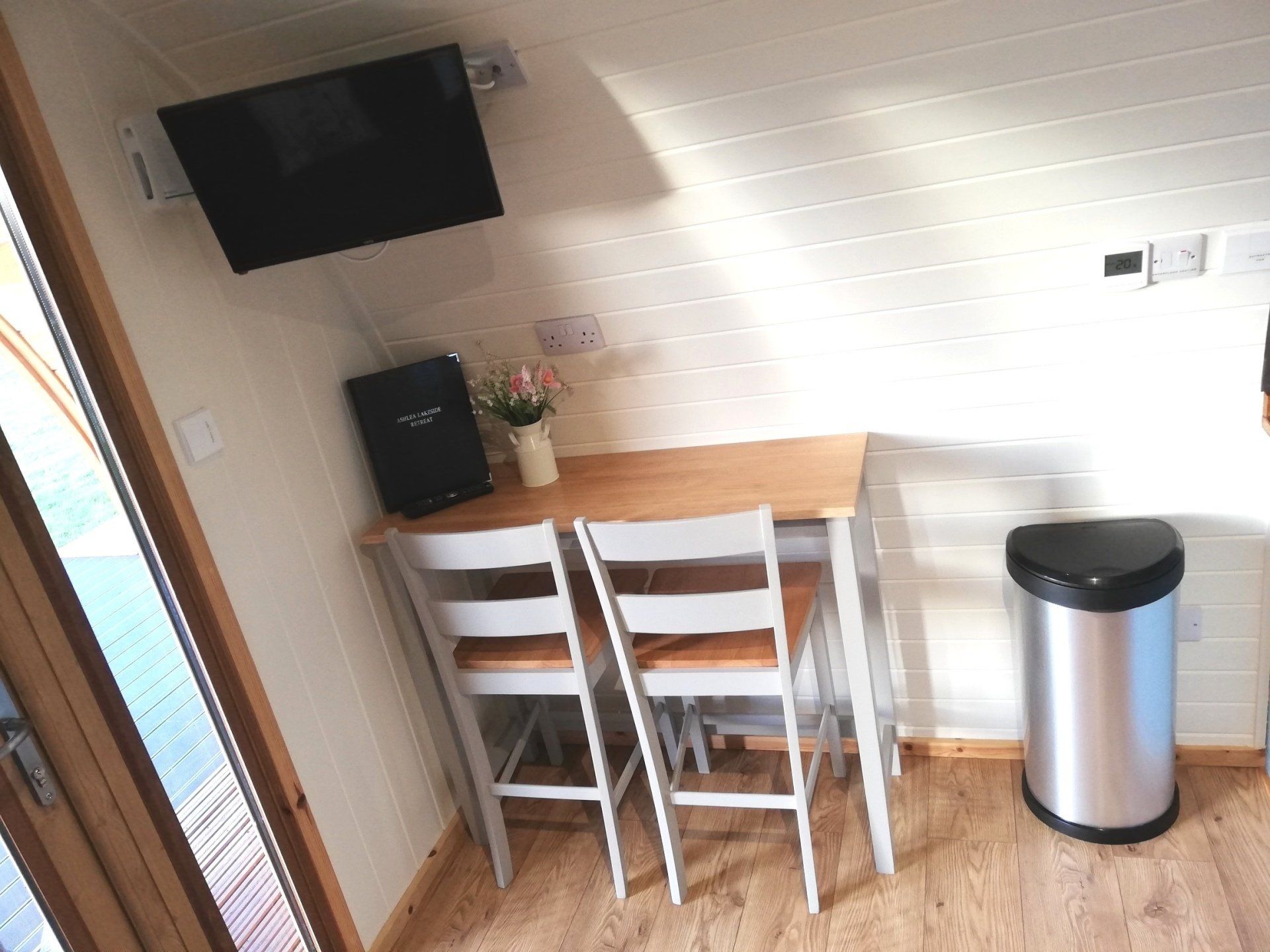 A room with a table and chairs and a trash can