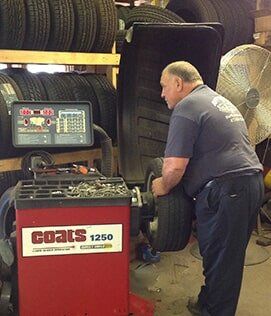 Man Adjusting Tire's Air - Tire Care in Northampton, MA Man Adjusting Tire's Air - Tire Care in Northampton, MA