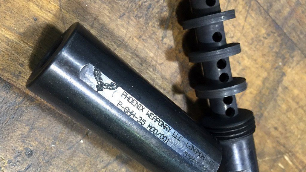 Black silencer with spiraled internal component; serial number visible.