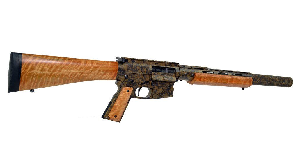 Tan and brown rifle with a wood-grain stock, handguard, and pistol grip against a white background.