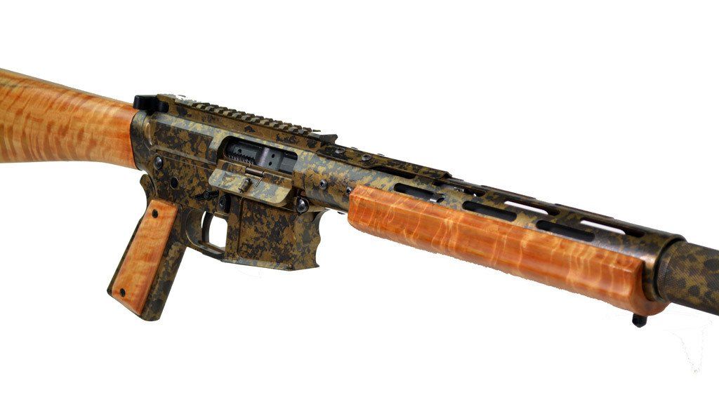 Camouflaged rifle with light wood stock, handguard, and pistol grip.