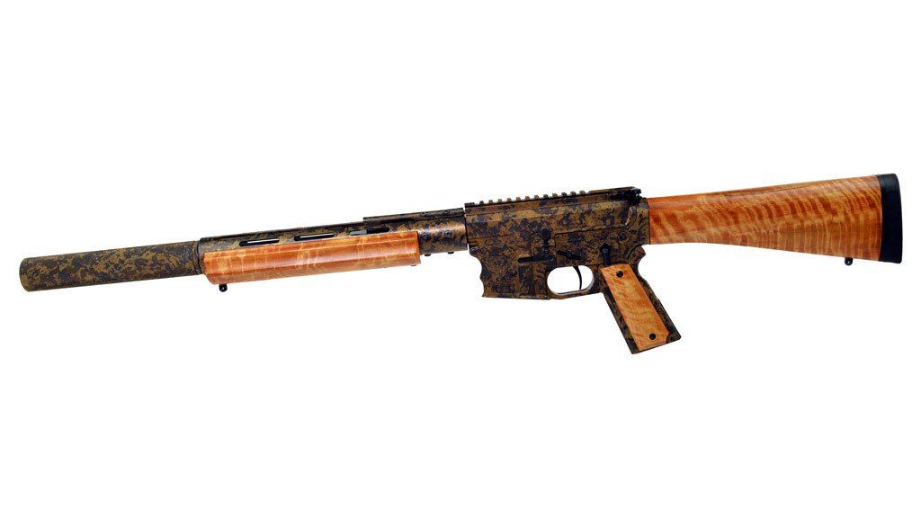 Custom rifle with brown wood stock, forend, and grip, with dark camouflage metal finish.