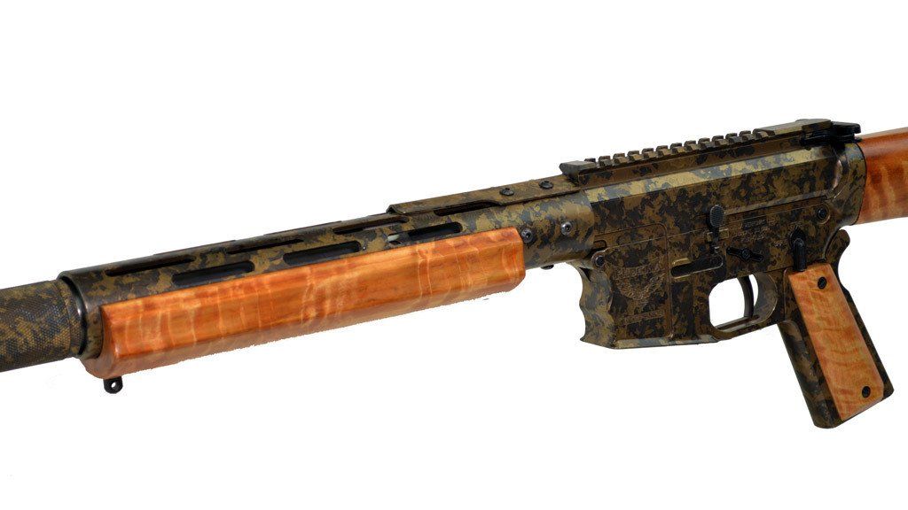Gun with wood accents, camouflaged barrel and receiver.