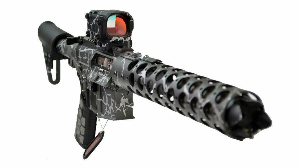 An AR-15 style rifle with a black and gray camo pattern and a red dot sight.
