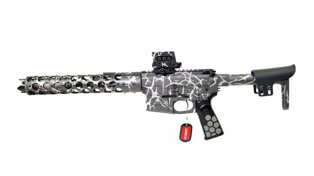 Custom painted rifle with red tag, optic, and black and white pattern.