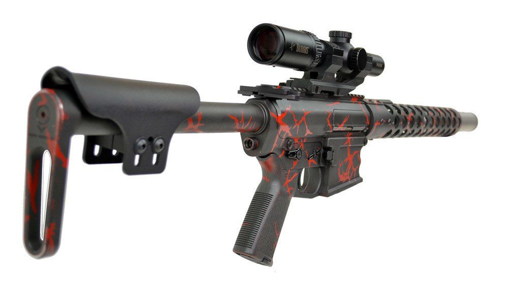 Black and red camouflage rifle with scope, on white background.