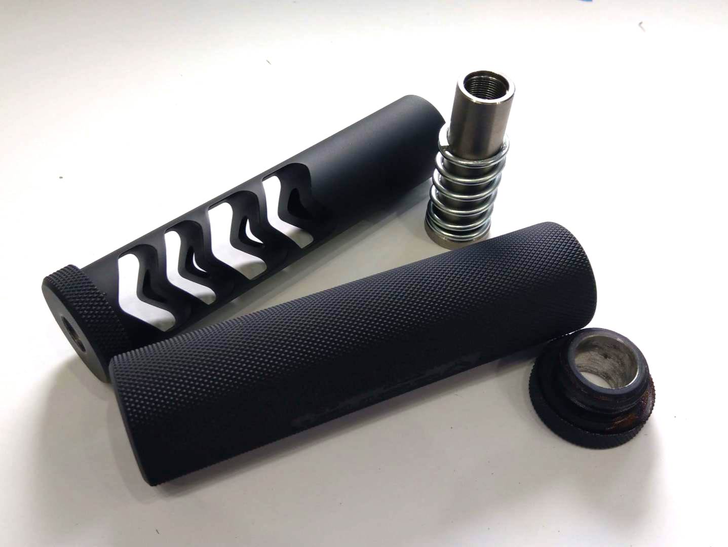Black and white bicycle handlebar grips with silver internal components on a white surface.