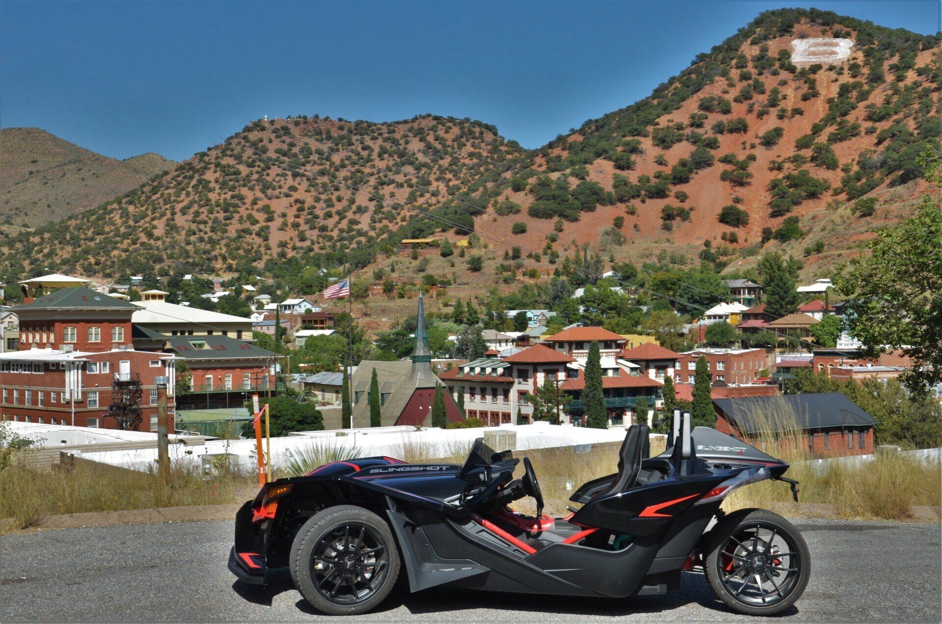 Black Polaris Slingshot on scenic road