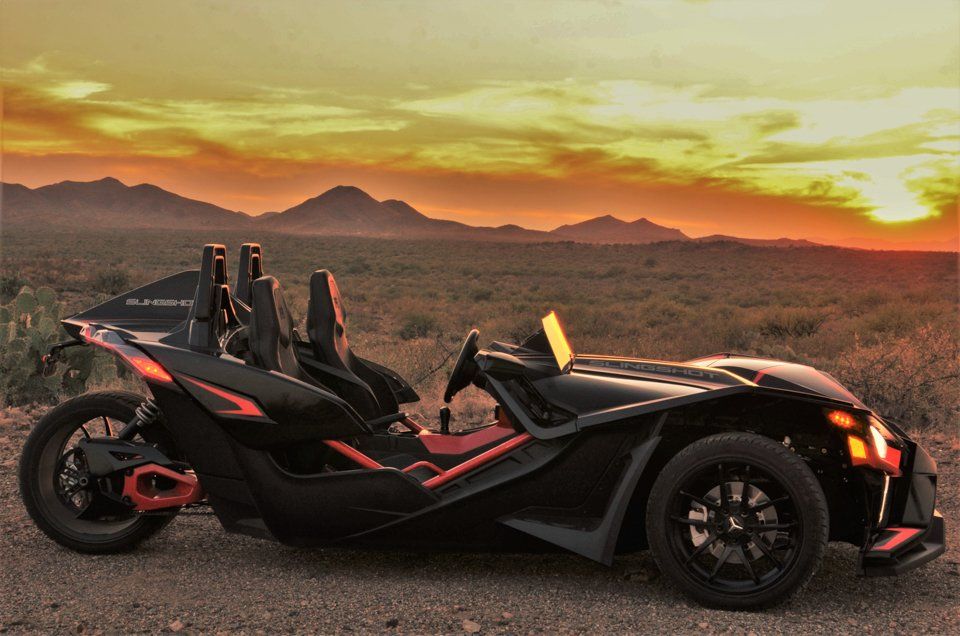 Black Polaris Slingshot on scenic road during Sunset Cruise Tour