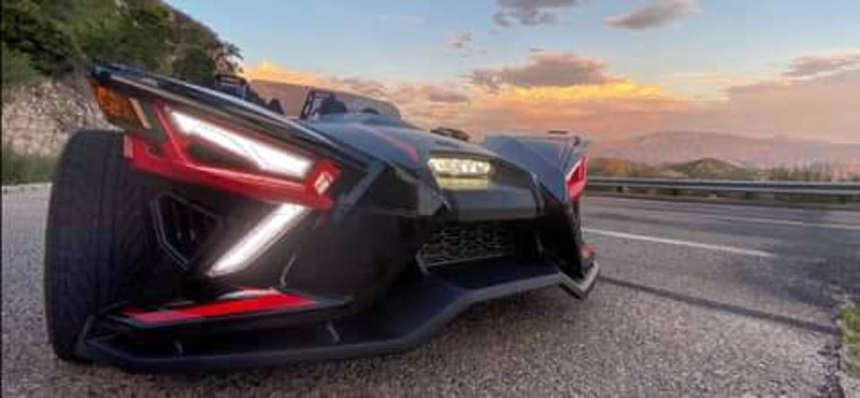 Black Polaris Slingshot on scenic road