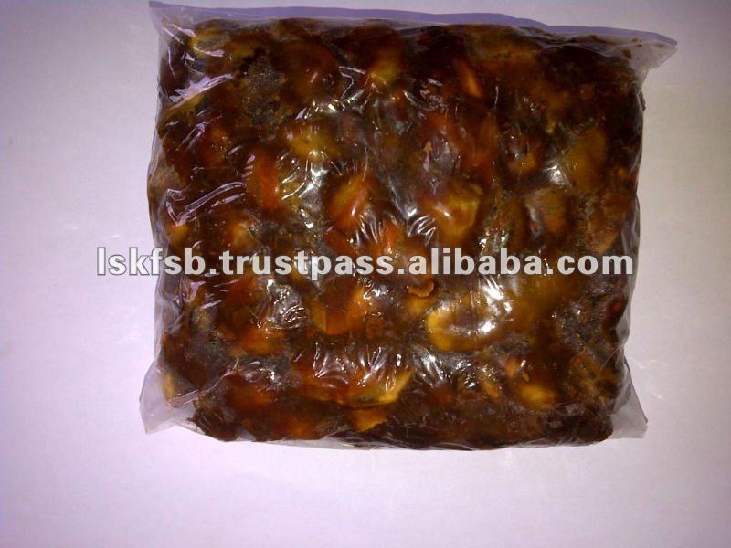 A plastic bag filled with brown, sticky tamarind fruits.