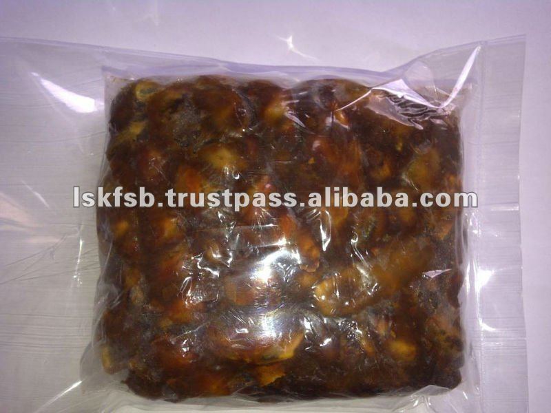 Tamarind paste in a clear plastic bag, brown, ready for use.