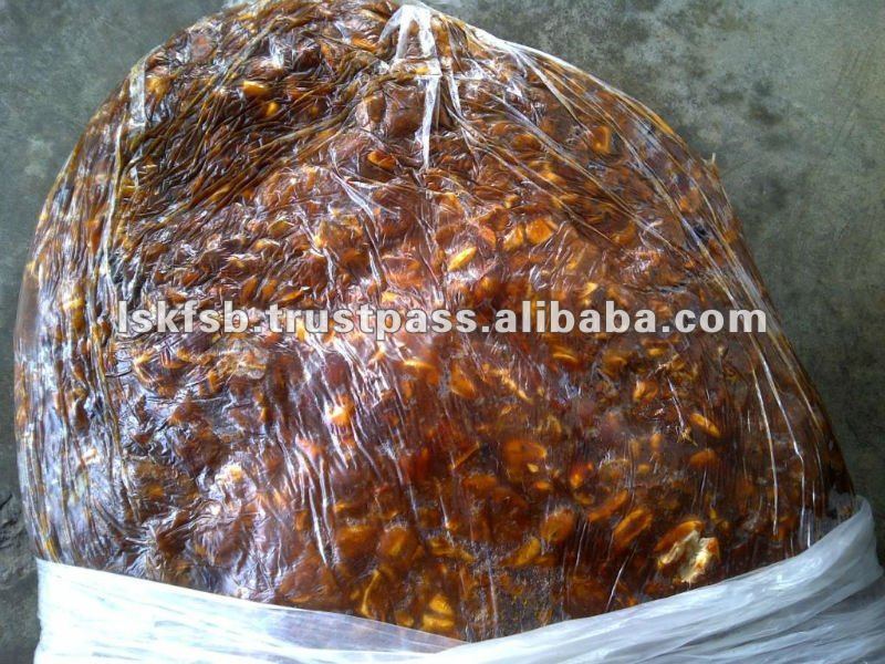 Bag of tamarind fruit pulp, brown with seeds, sealed in plastic.