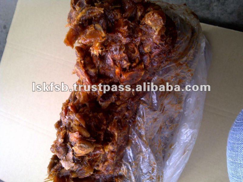 Tamarind pulp in a clear plastic bag on a light-colored surface, likely for sale.