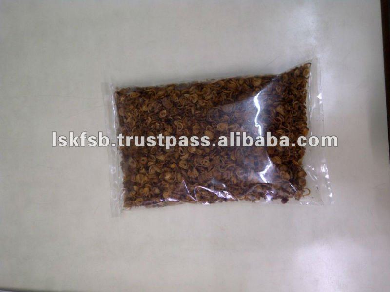 A clear plastic packet filled with brown, granular material, possibly food items, against a white surface.