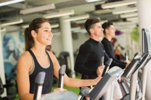 People exercising on treadmills in a bright gym