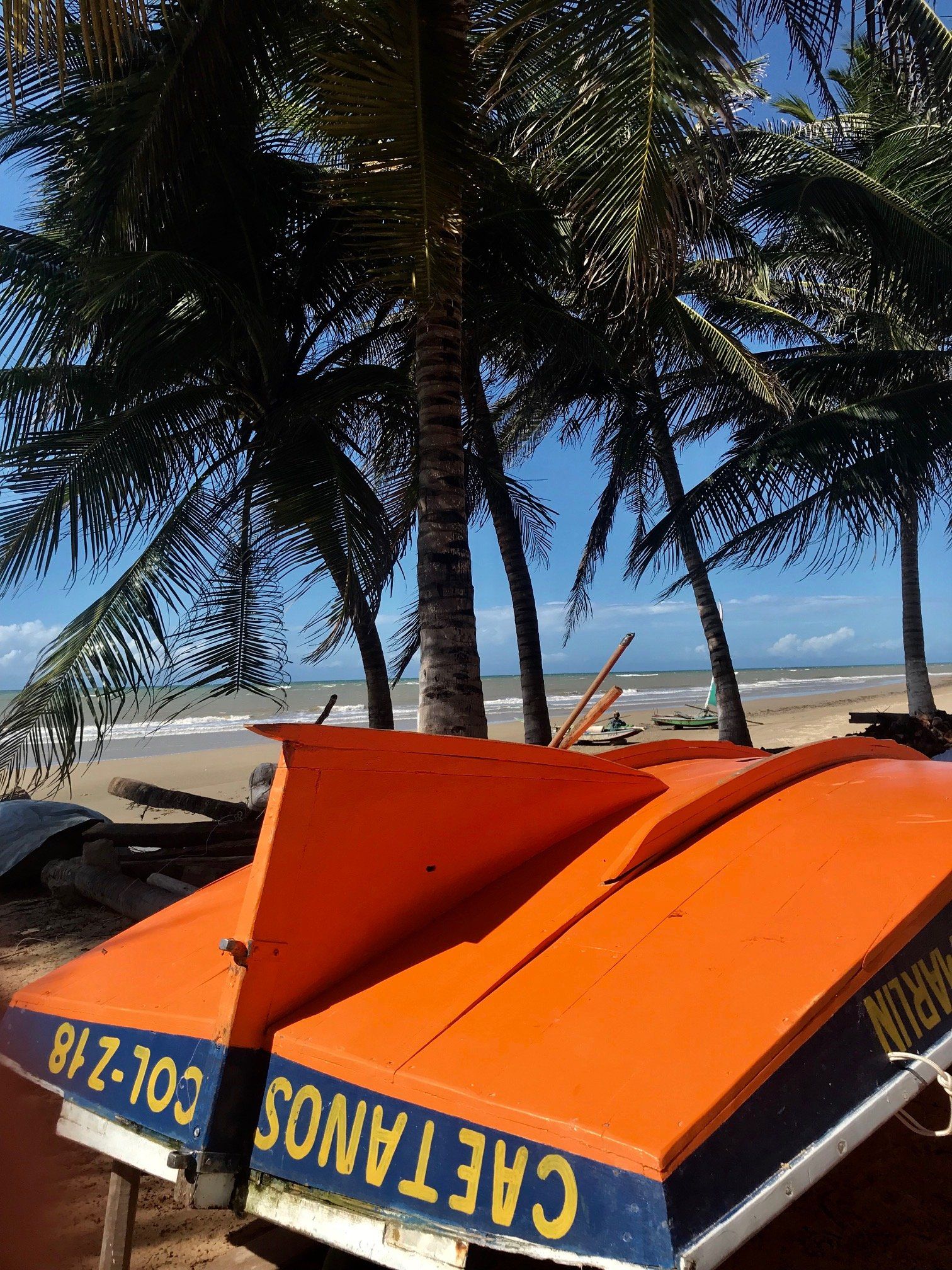 Um barco laranja virado, com a inscrição