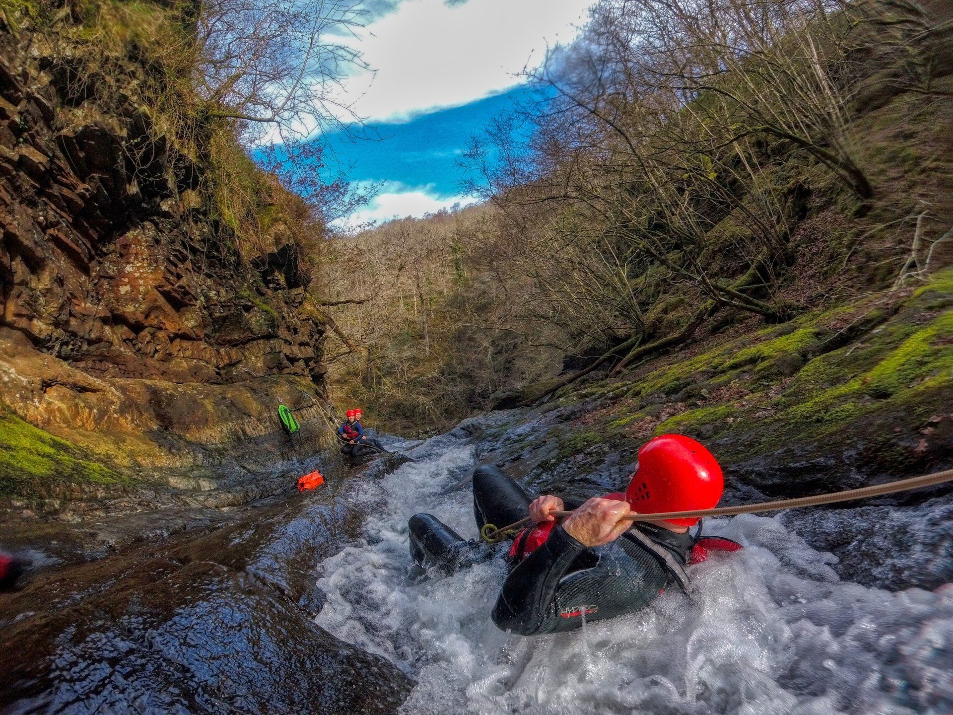 Someone lying down sliding down a slope with water around them
