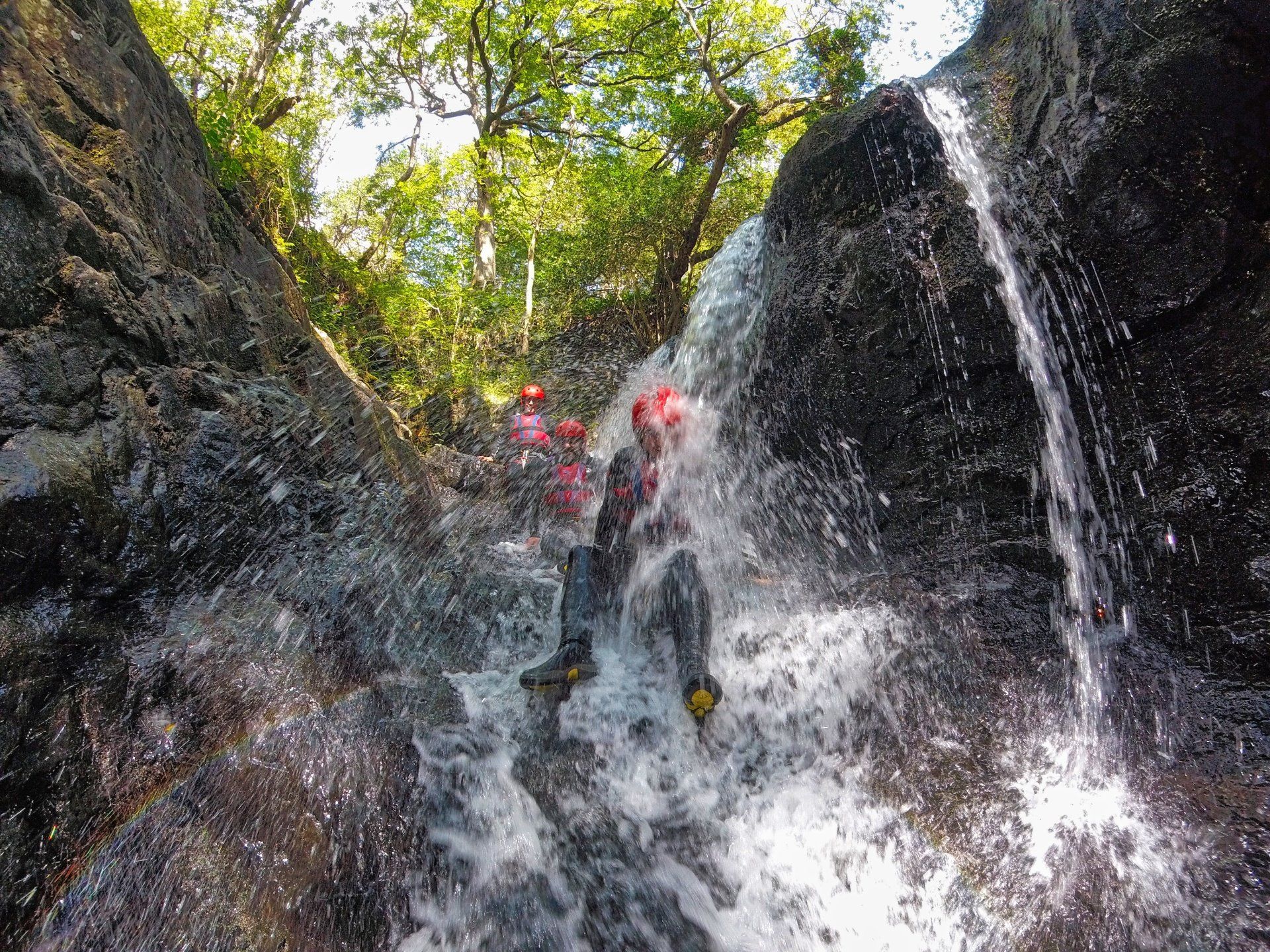 A person appearing from scrambling through a small waterfall