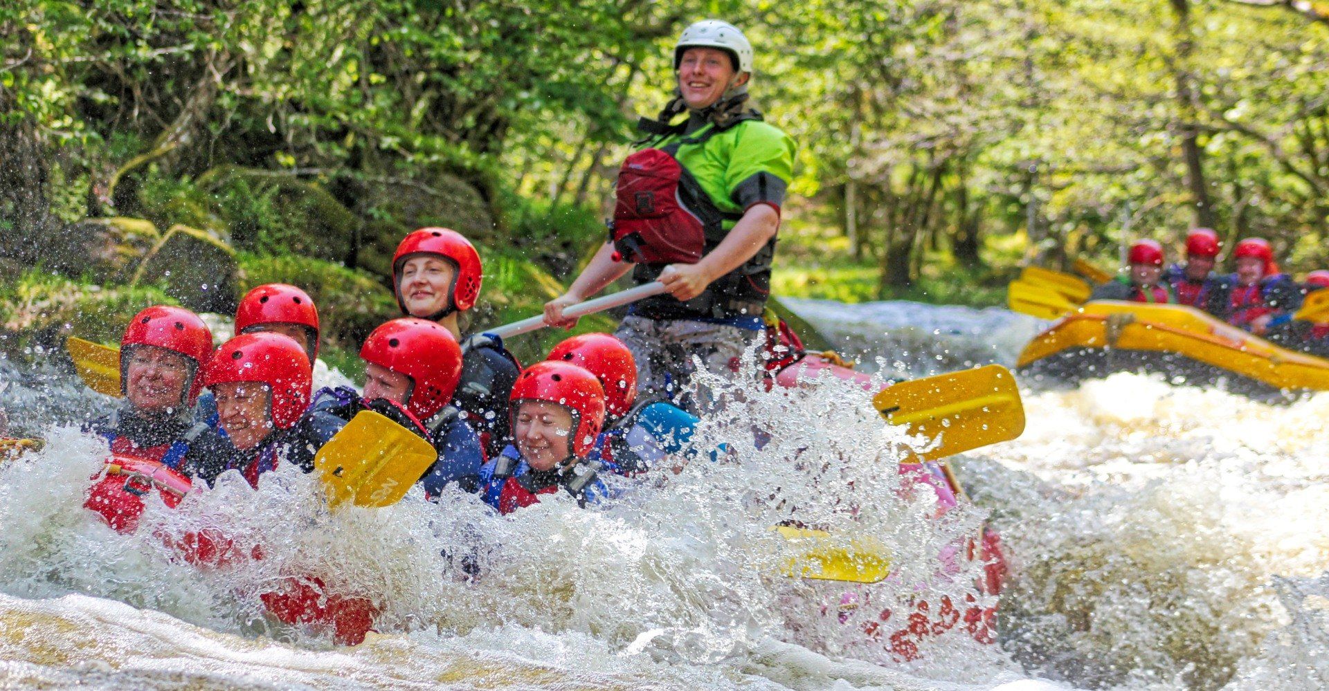 People smiling while they're rafting down the river