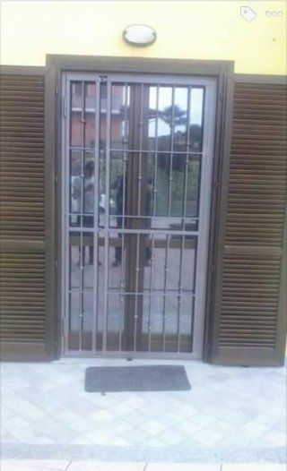 Porta con grata esteriore in ferro