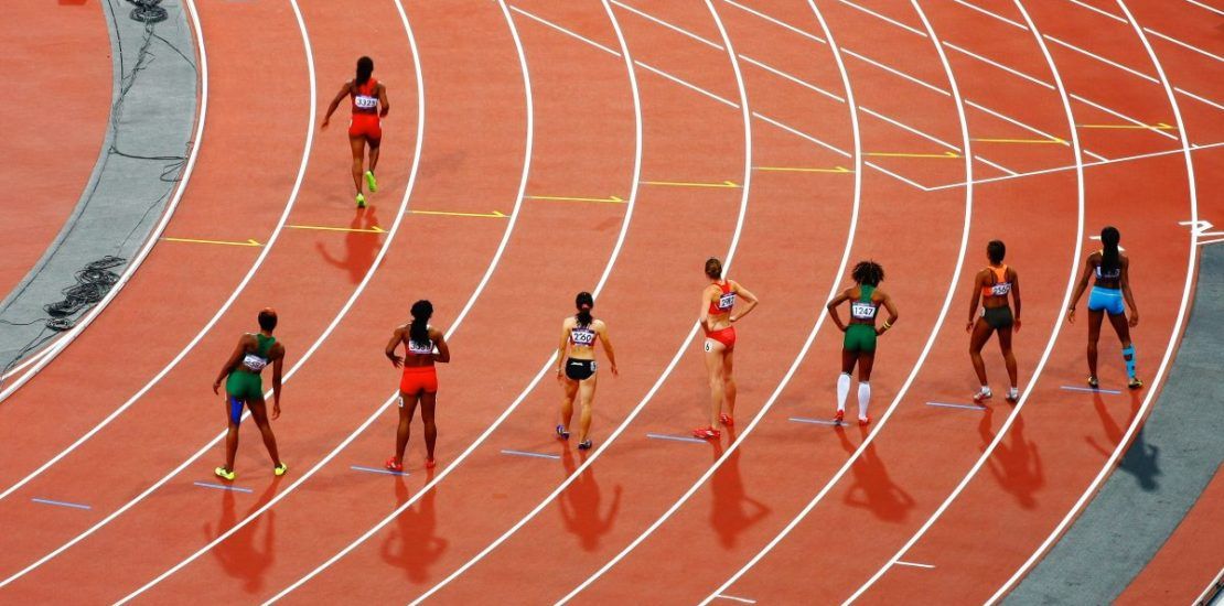 A group of people are running on a track.