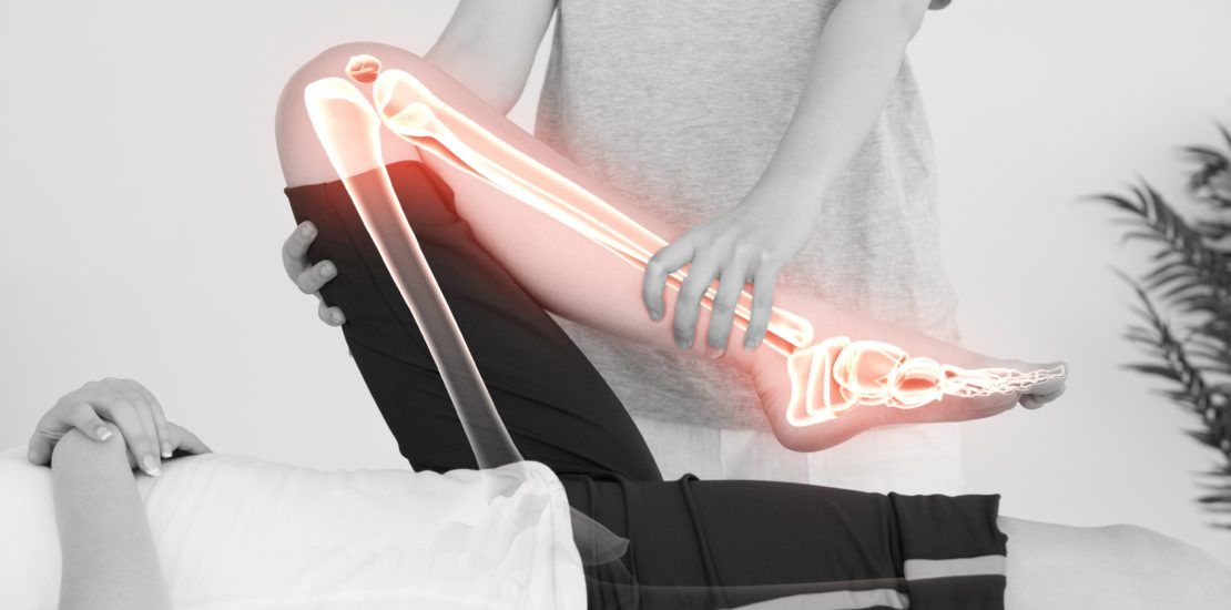 A person is getting a massage with a glowing skeleton of their leg.