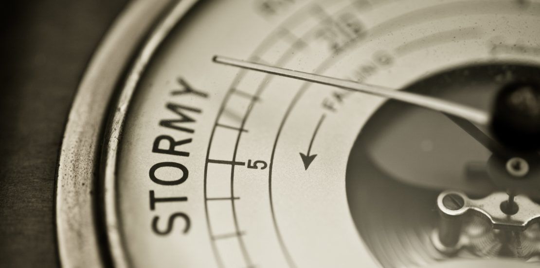 A close up of a weather gauge that says stormy