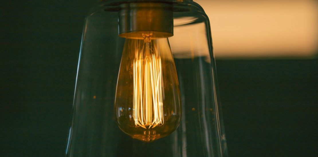 A close up of a light bulb hanging from a ceiling.