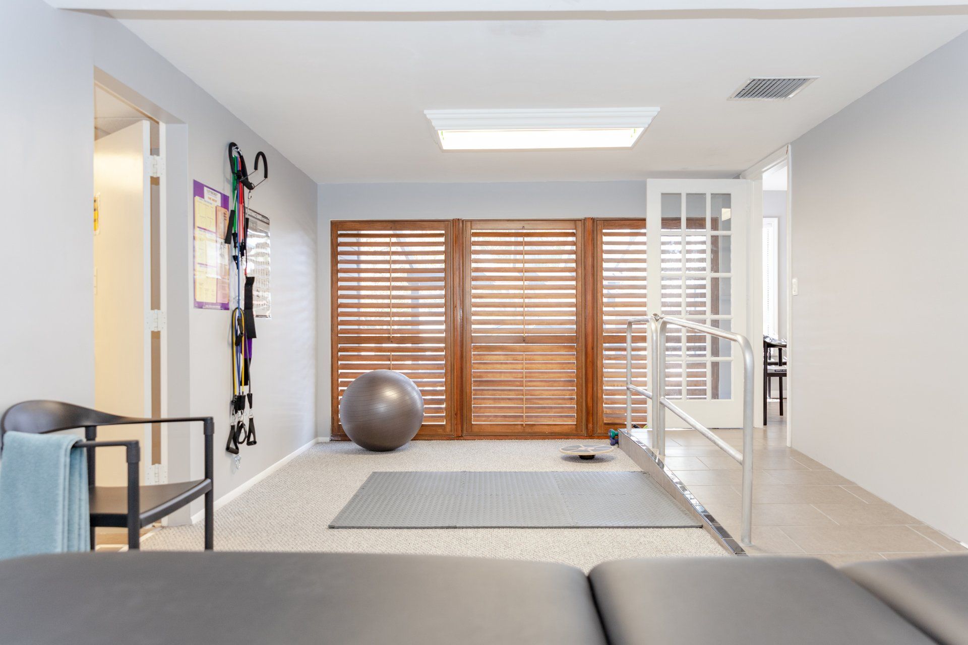 A room with a couch and chairs and a pilates ball