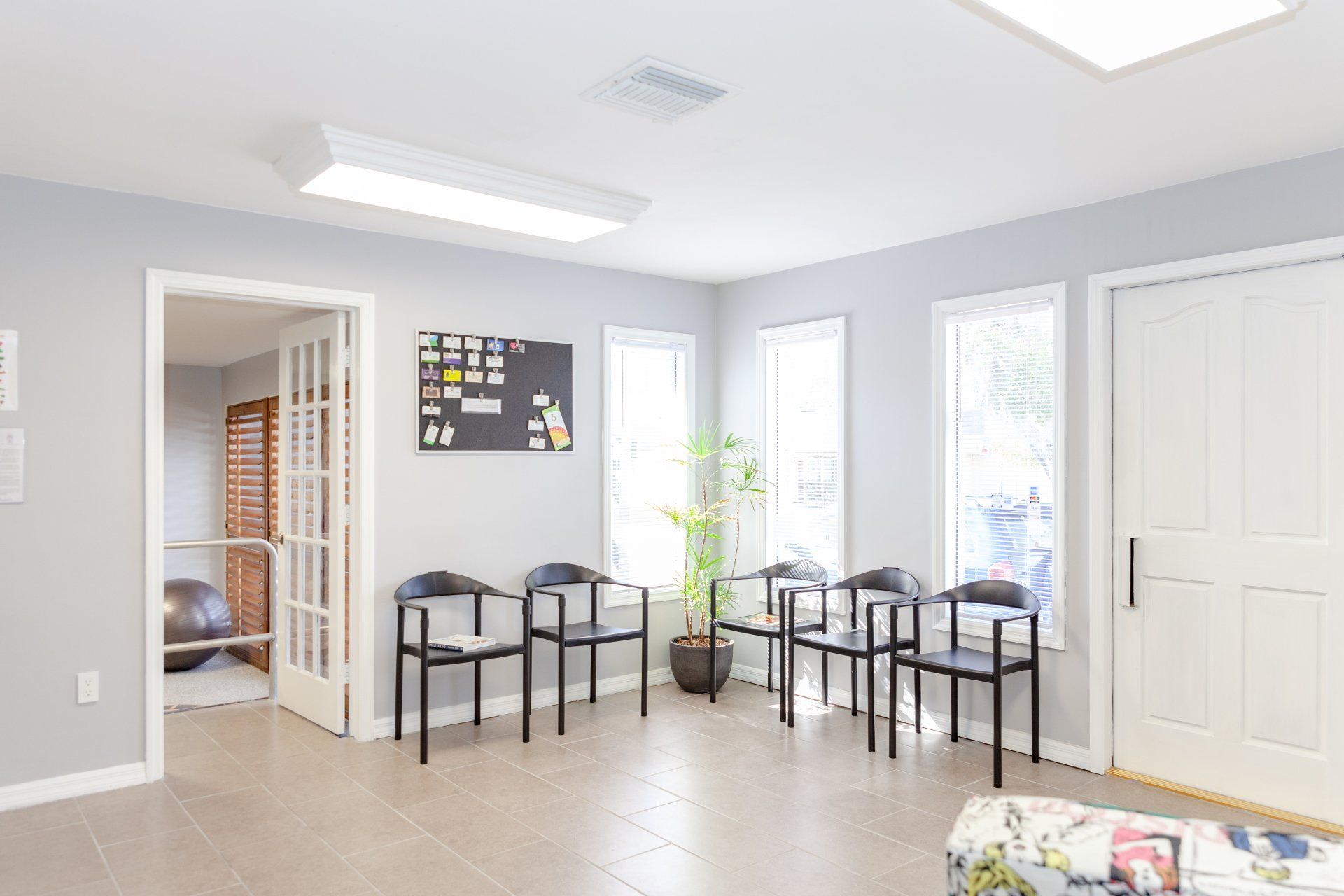 A waiting room with a lot of chairs and windows.