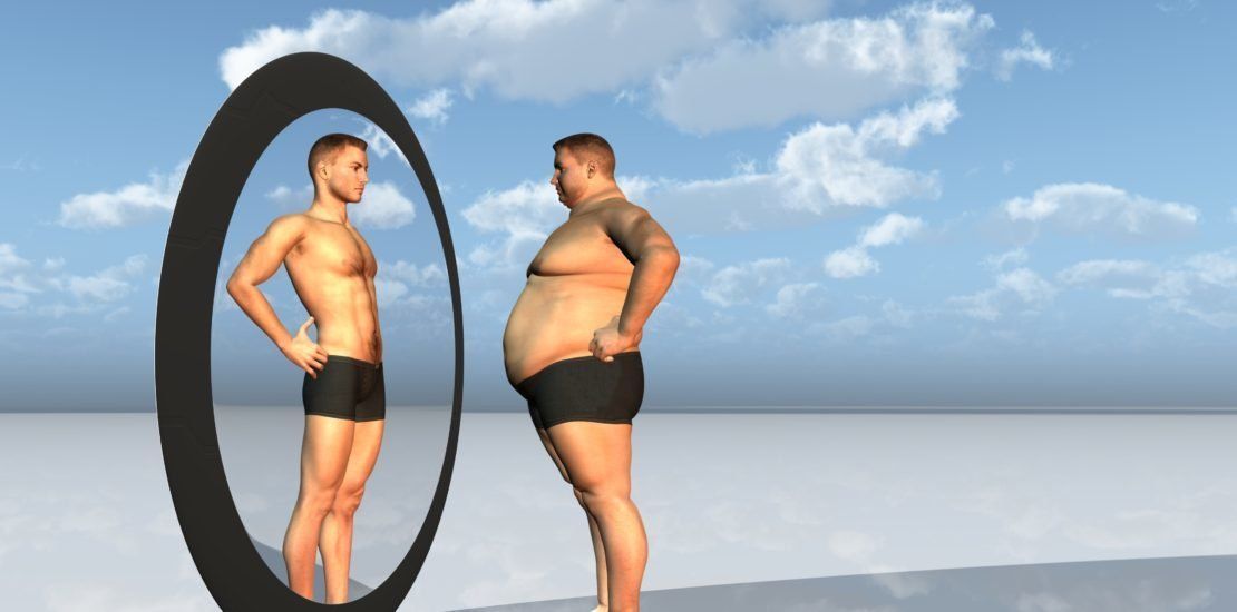 A man is standing in front of a mirror and looking at himself