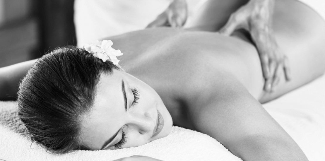 A woman is laying on a table getting a massage.