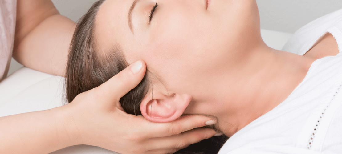 A woman is getting a head massage at a spa.