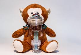 A stuffed monkey is wearing an oxygen mask.